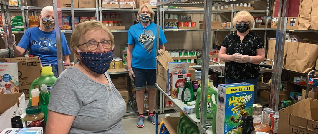 St. Francis Community Assistance volunteers in the food pantry among stocked shelves