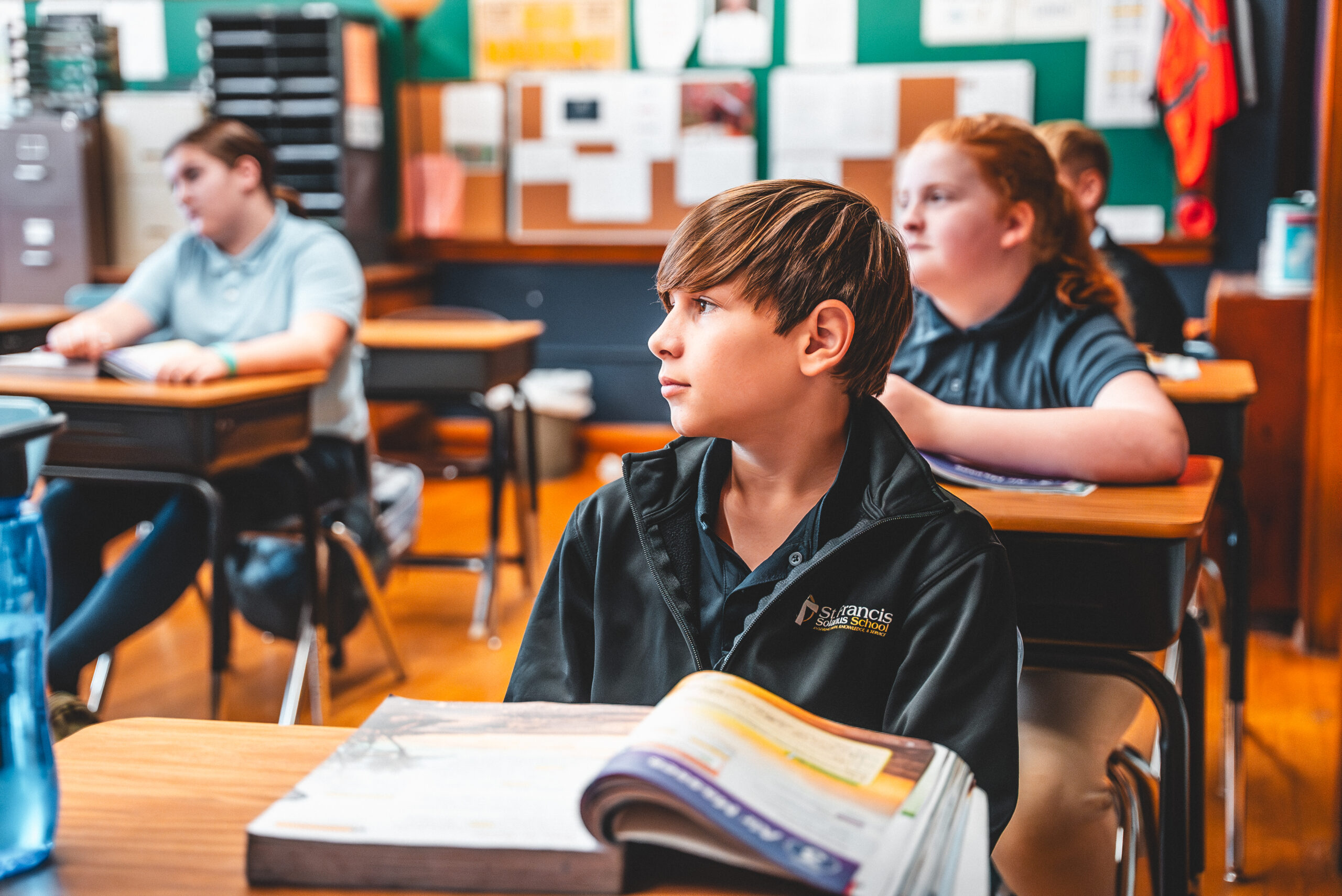A St. Francis Solanus School student reading at his desk