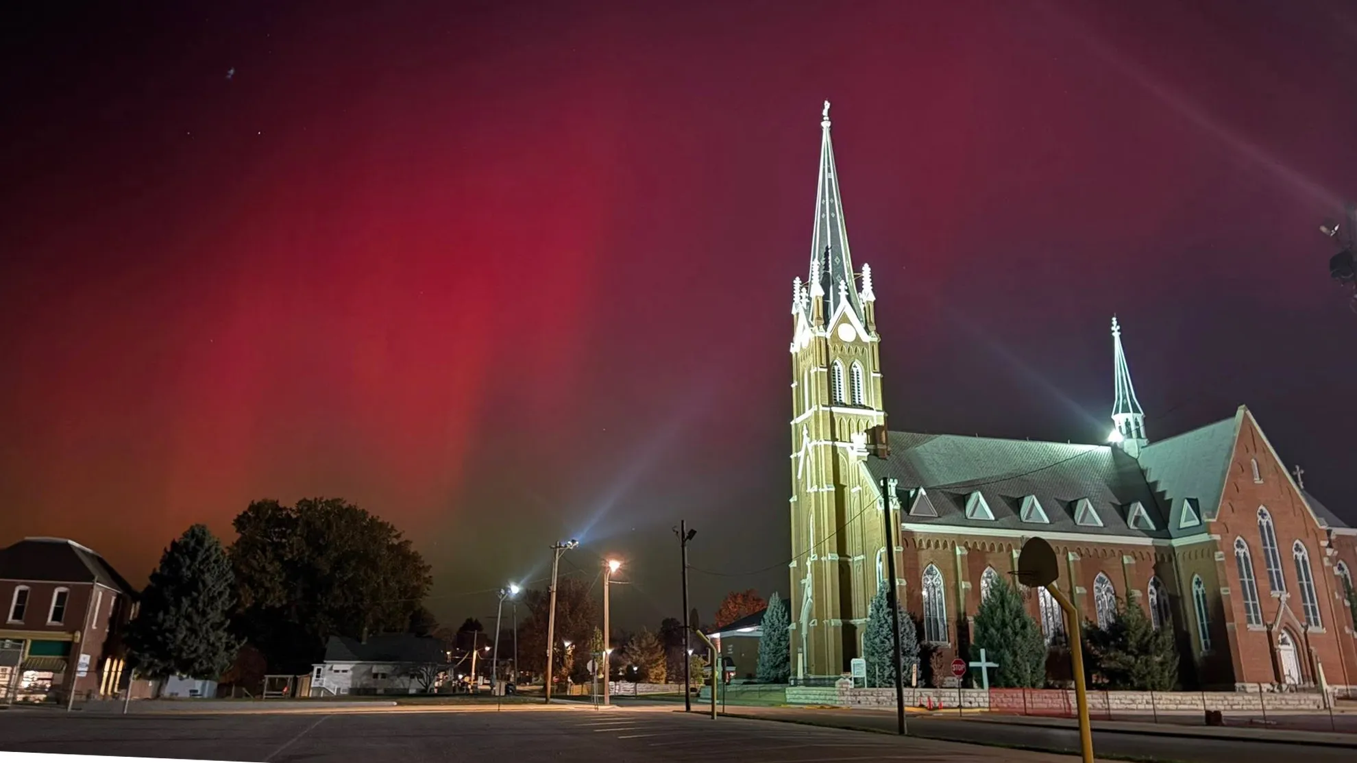 St. Francis Solanus Church lit up at night beneath the northern lights