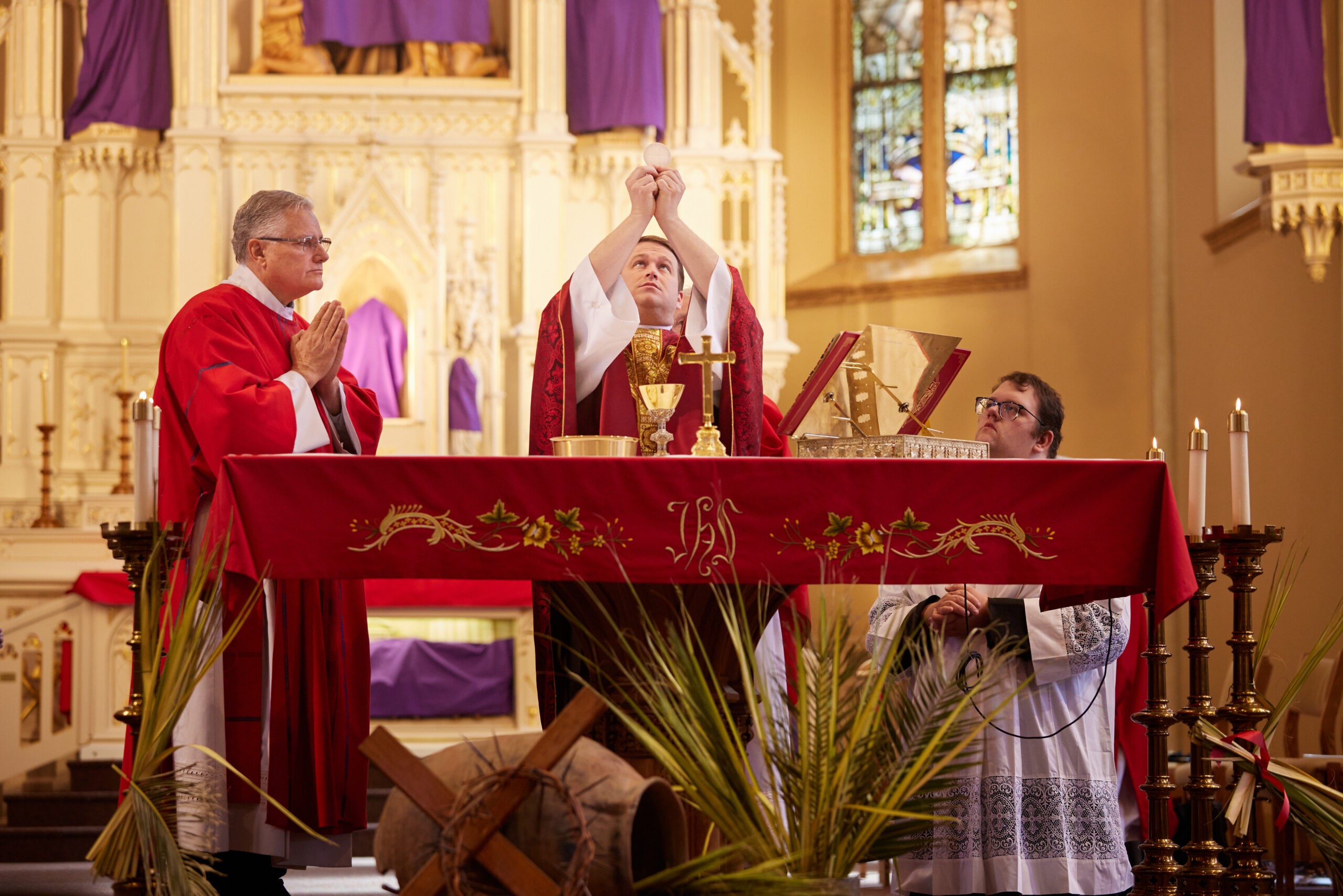 Fr. Steven Arisman elevating the Eucharist at the altar of St. Francis Solanus Church
