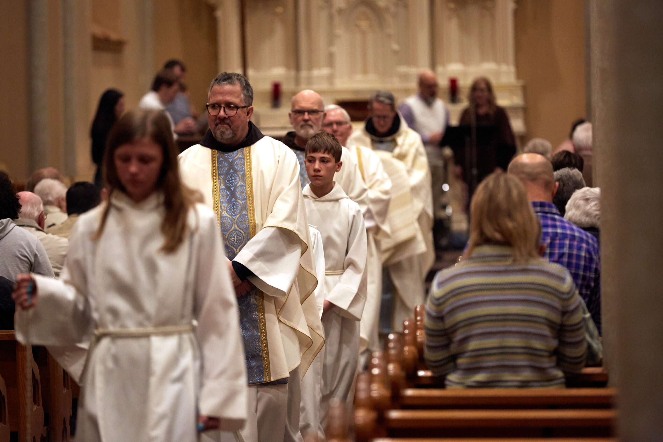Parishioners in the pews as the priest and altar servers process down the aisle at St. Francis Solanus
