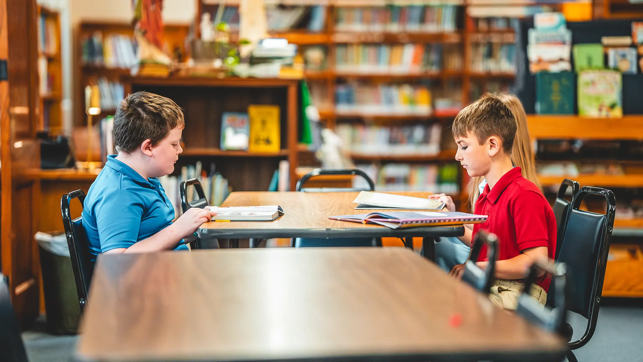 Two St. Francis students reading at a table in the school library