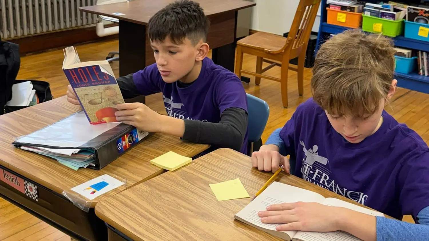 St. Francis students in purple shirts reading chapter books at their desks