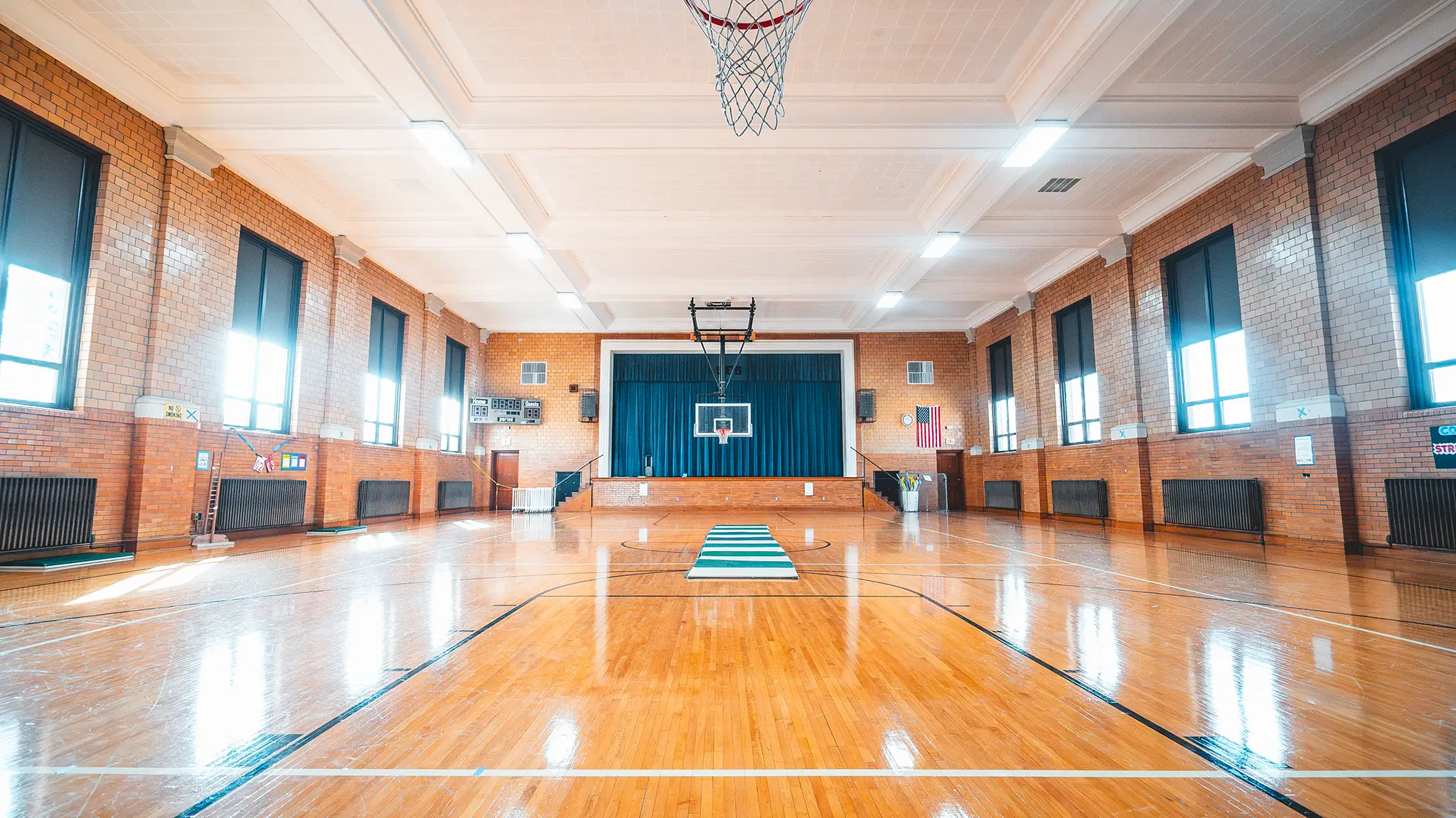 The St. Francis Solanus School gym, with its wood floor, brick walls, and stage