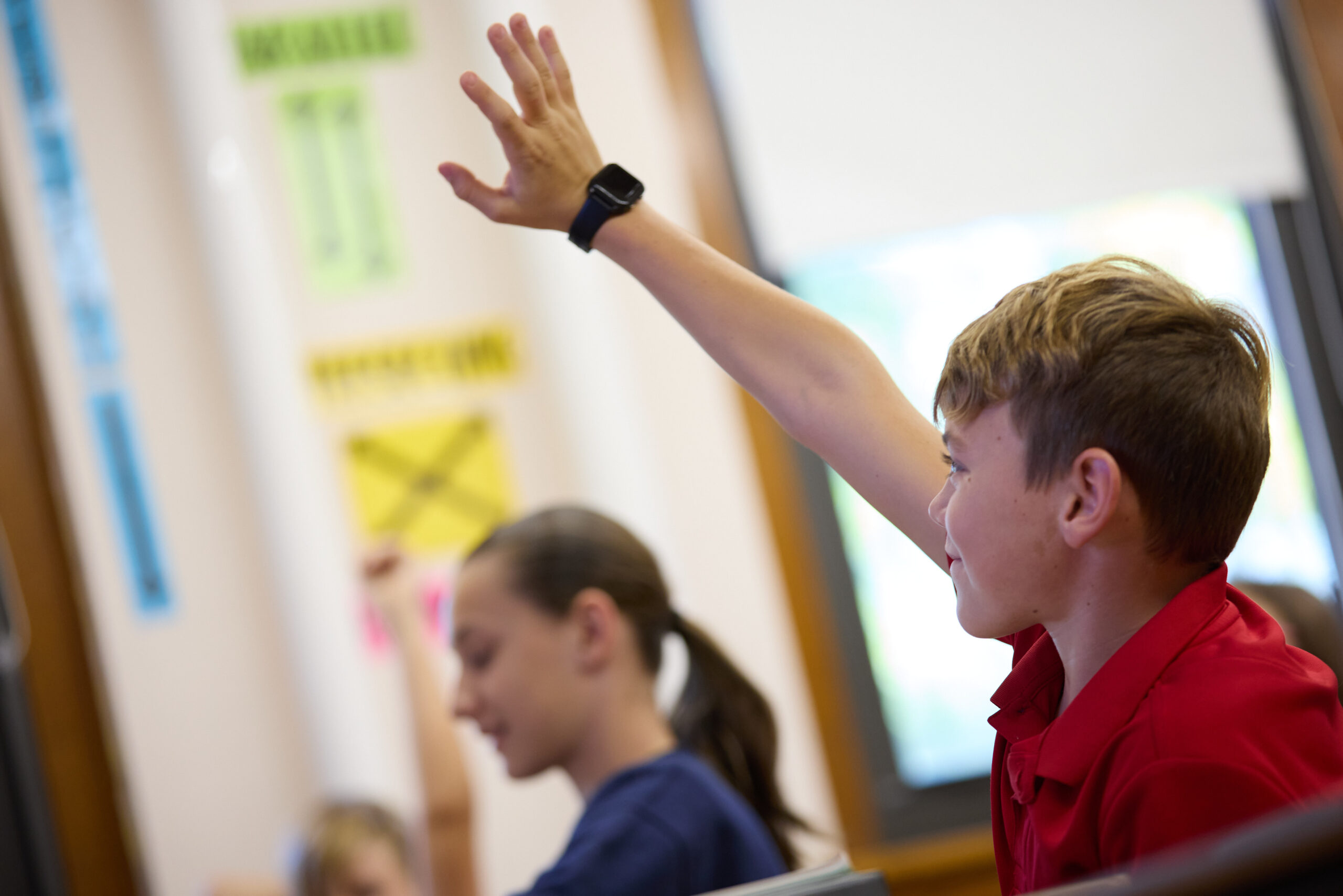 A St. Francis student raising his hand to answer a question in class