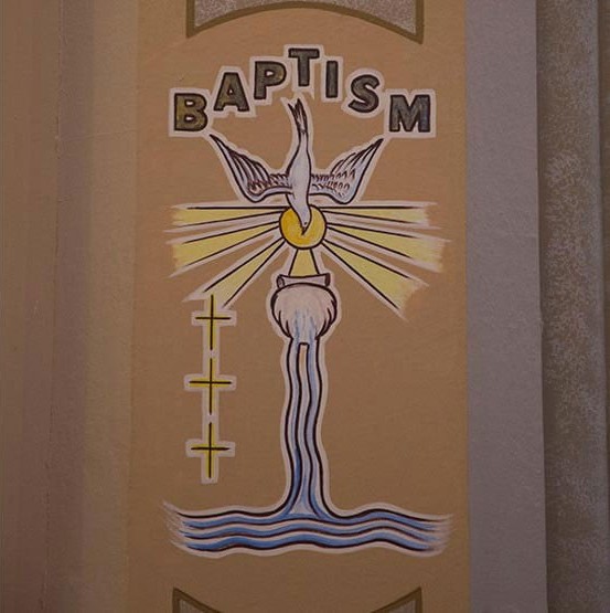 The painted baptism mural, with a dove and flowing water, inside St. Francis Solanus Church