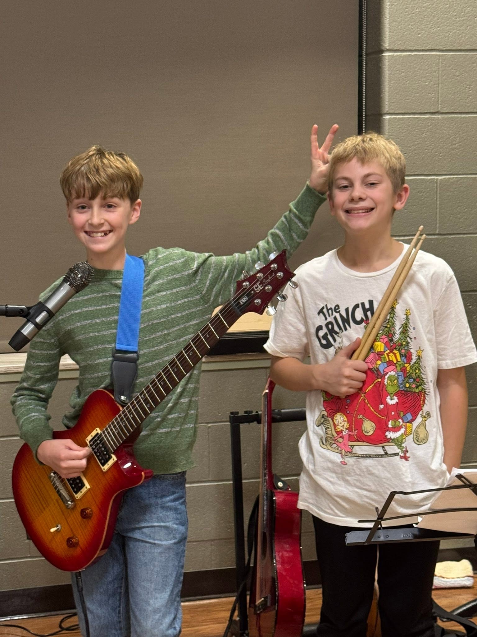 Two St. Francis boys with guitars, smiling in the music room